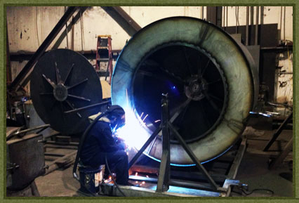 Welding a washing machine basket at MorFab.